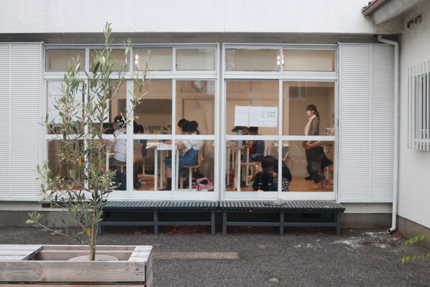 本店の外観。窓の向こうに授業中の子どもたちが見える